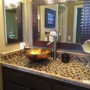 the master bath had two separate opulent tile countertops with gold vessel sinks.