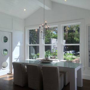 dining room with a view of the backyard. fun porthole pantry door on the left